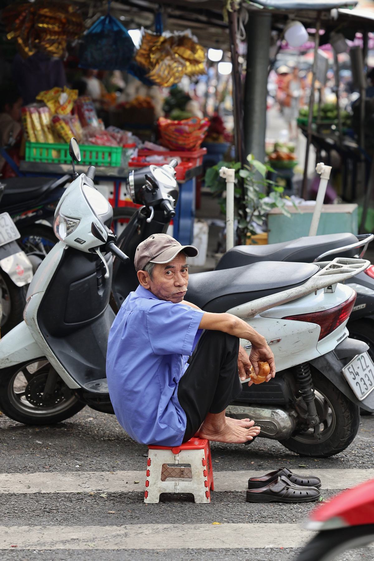An older man sitting alone at a market
